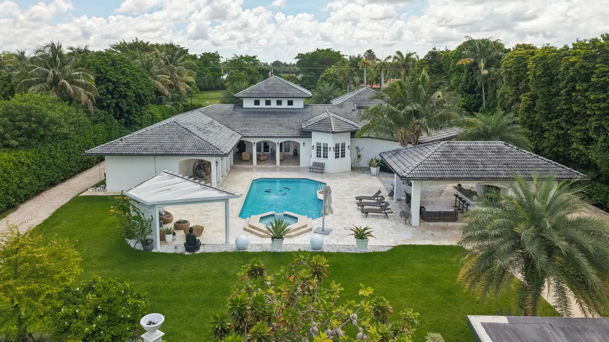 Aerial view of a gated South Florida estate, its pool deck and surrounding acreage