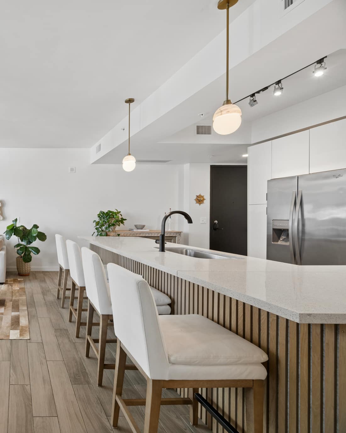 Bright open-plan condo interior with a marble dining table and city view from the balcony