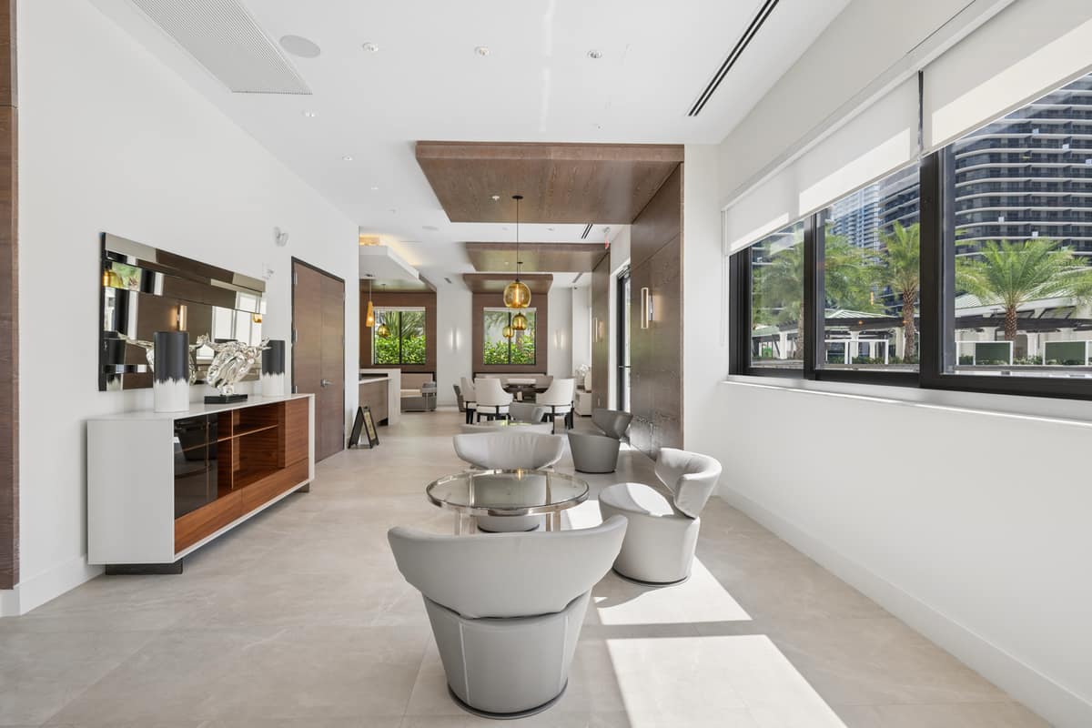 Modern building lobby with lounge seating, a console table, and street-facing windows